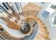 Elegant curved staircase with custom iron railing and a unique pendant lighting fixture overhead at 11453 Glowing Sunset Ln, Las Vegas, NV 89135