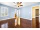 Blue bedroom featuring wood floors, ceiling fan, and shuttered window at 11894 Snow Bank St, Las Vegas, NV 89183