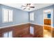 Bedroom featuring a ceiling fan, wood floors, and shuttered windows at 11894 Snow Bank St, Las Vegas, NV 89183