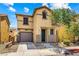 Two-story home featuring tan stucco, a tile roof, a well-manicured lawn, and an attached garage at 11894 Snow Bank St, Las Vegas, NV 89183