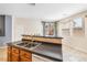 View of the kitchen bar with double sink, wood cabinets and black countertop at 11894 Snow Bank St, Las Vegas, NV 89183