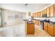 Well-lit kitchen with wood cabinets, stainless steel appliances, breakfast bar, and tile floors at 11894 Snow Bank St, Las Vegas, NV 89183
