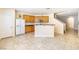 Spacious kitchen featuring wood cabinets, white appliances, a breakfast bar, and tile floors at 11894 Snow Bank St, Las Vegas, NV 89183