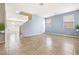 Bright, open living room featuring neutral walls, large windows, stylish tile flooring, and staircase access at 11894 Snow Bank St, Las Vegas, NV 89183