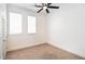 Cozy bedroom with neutral carpet, two windows, and a ceiling fan for comfort at 1319 Red Baron Ln, Boulder City, NV 89005