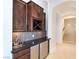 Elegant wet bar with dark wood cabinetry, black countertop, wine rack, and stainless steel mini-fridge at 1319 Red Baron Ln, Boulder City, NV 89005