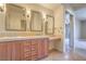 Elegant bathroom featuring double sinks, warm wood cabinetry, and marble countertops at 15 Via Mantova # 302, Henderson, NV 89011