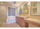 Bathroom with double vanity, separate tub, tiled walls, and a glass-enclosed shower at 15 Via Mantova # 302, Henderson, NV 89011