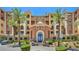 Beautiful condo exterior with manicured landscaping and swaying palm trees on a bright sunny day at 15 Via Mantova # 302, Henderson, NV 89011