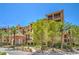 Beautiful building exterior showing elegant landscaping and tall palm trees under a bright sunny sky at 15 Via Mantova # 302, Henderson, NV 89011