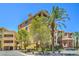 Lovely building exterior showcasing beautiful landscaping with tall palm trees under a bright blue sky at 15 Via Mantova # 302, Henderson, NV 89011