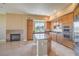Open kitchen featuring a central island, stainless appliances, a tile fireplace, and ample cabinet space at 15 Via Mantova # 302, Henderson, NV 89011