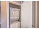 A stacked washer and dryer unit with a white door and neutral walls at 15 Via Mantova # 302, Henderson, NV 89011