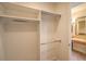 Spacious walk-in closet with built-in shelving and hanging rods; primary bathroom in background at 15 Via Mantova # 302, Henderson, NV 89011