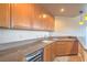 Modern wet bar featuring sleek countertops, a wine fridge, wooden cabinets, and stylish pendant lighting at 15 Via Mantova # 302, Henderson, NV 89011