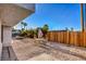 Spacious backyard with gravel landscaping, wooden fence and an outdoor seating area under a shaded umbrella at 1564 Vegas Valley Dr, Las Vegas, NV 89169