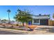 Charming single-story home with a blue door, attached garage, and front yard landscaping at 1564 Vegas Valley Dr, Las Vegas, NV 89169