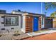 The house features a vibrant blue front door and modern wood accents at 1564 Vegas Valley Dr, Las Vegas, NV 89169