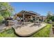 Spacious backyard patio with comfortable seating, an outdoor kitchen, and a well-manicured lawn at 16 Mallard Creek Trl, Henderson, NV 89052