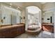 Elegant bathroom with dual vanities, soaking tub, and a glass block shower at 16 Mallard Creek Trl, Henderson, NV 89052