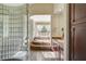 Luxurious bathroom features a glass block shower and a soaking tub with natural light at 16 Mallard Creek Trl, Henderson, NV 89052