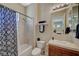 Well-lit bathroom includes a shower-tub combo, decorative curtain and a neutral-toned vanity at 16 Mallard Creek Trl, Henderson, NV 89052