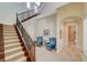 Grand foyer features a winding staircase with wrought iron railing and tufted sitting chairs at 16 Mallard Creek Trl, Henderson, NV 89052