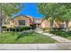 Charming two-story home with beautifully landscaped front yard and walkway leading to gated entrance at 16 Mallard Creek Trl, Henderson, NV 89052
