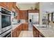 A modern kitchen featuring stainless steel appliances, granite countertops and wood cabinets at 16 Mallard Creek Trl, Henderson, NV 89052