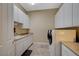 Well-organized laundry room with washer, dryer, sink, counter space, and ample white cabinet storage at 16 Mallard Creek Trl, Henderson, NV 89052