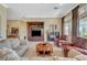 Cozy living room with a fireplace, neutral decor, and comfortable seating arrangement at 16 Mallard Creek Trl, Henderson, NV 89052