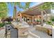 Large outdoor kitchen with an island, bar seating, stainless grill, and a stone-clad facade at 16 Mallard Creek Trl, Henderson, NV 89052