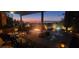 Inviting outdoor kitchen and living space featuring a built-in grill and city views at dusk at 16 Mallard Creek Trl, Henderson, NV 89052