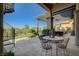 Inviting outdoor patio featuring a cozy dining set, spiral staircase, and lush landscaping at 16 Mallard Creek Trl, Henderson, NV 89052