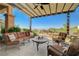 Inviting covered patio featuring plush seating, a fire pit, and beautiful views for cozy outdoor gatherings at 16 Mallard Creek Trl, Henderson, NV 89052