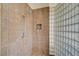 Modern tiled shower featuring glass block wall and convenient niche storage at 16 Mallard Creek Trl, Henderson, NV 89052