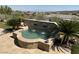 Custom backyard spa features a stone waterfall feature and lush landscaping at 16 Mallard Creek Trl, Henderson, NV 89052