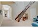 Elegant staircase features wrought iron railing, plush carpet, and a cozy seating area with blue armchairs at 16 Mallard Creek Trl, Henderson, NV 89052