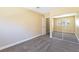 Bedroom with neutral carpet features mirrored closet, bright lighting, and a window for natural light at 1836 N Decatur Blvd # 203, Las Vegas, NV 89108