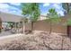 Landscaped backyard with a covered patio, rock features, and privacy fence at 2279 Keego Harbor St, Henderson, NV 89052
