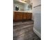 Bathroom with a wooden dual sink vanity, large mirror and modern wood-look flooring at 2707 Gardenia Flower Ave, North Las Vegas, NV 89031