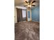 Well-lit bedroom with neutral carpet, a ceiling fan, and dark blue accent wall at 2707 Gardenia Flower Ave, North Las Vegas, NV 89031