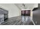 Spacious living room with decorative fireplace, ceiling fan, and gray wood-look flooring at 2707 Gardenia Flower Ave, North Las Vegas, NV 89031