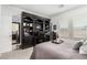 Bright bedroom featuring a home office area with dark wood shelving and desk, and two large windows at 288 Whitney Crest St, Henderson, NV 89015