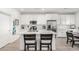 A modern kitchen with stainless appliances, white cabinets and an island with breakfast bar seating at 288 Whitney Crest St, Henderson, NV 89015