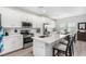 Bright kitchen features white cabinets, stainless steel appliances, and a spacious island with seating at 288 Whitney Crest St, Henderson, NV 89015