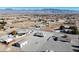 Wide aerial shot showcasing a sprawling desert landscape with scattered homes and mountainous backdrop under a clear blue sky at 3580 Prairie Ave, Pahrump, NV 89048