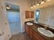 Well-lit bathroom boasts double sinks with granite countertops and leads to a bedroom with double closets at 3580 Prairie Ave, Pahrump, NV 89048