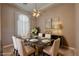 Formal dining room featuring a marble table, six chairs, decorative chandelier, and modern sideboard at 3580 Prairie Ave, Pahrump, NV 89048
