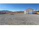 Detached garage on a gravel lot offering ample parking and storage space with mountain views in the distance at 3580 Prairie Ave, Pahrump, NV 89048